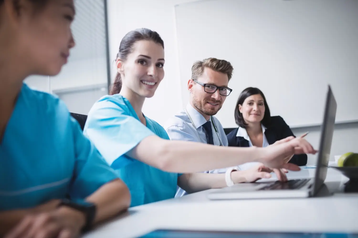 Doctors discussing over laptop in meeting